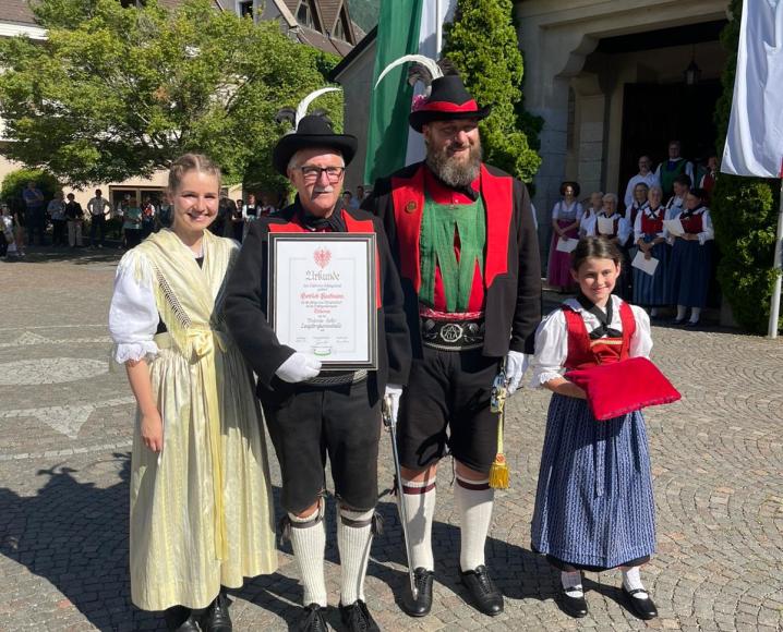 Melanie Mair, der geehrte Gottlieb Kaufmann, Hauptmann Christian Reiterer und Jungmarketenderin Tabea Reiterer bei der Übergabe der Ehrentafel